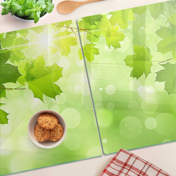 Tagliere in vetro temperato con motivo di foglie illuminate dai raggi del sole