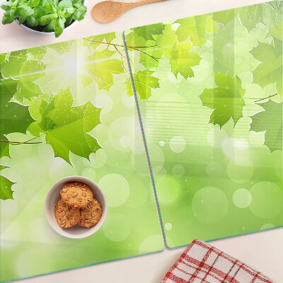 Tagliere in vetro temperato con motivo di foglie illuminate dai raggi del sole