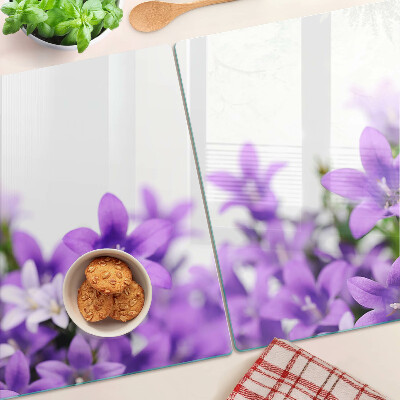 Tagliere in vetro con motivo di fiori viola sullo sfondo