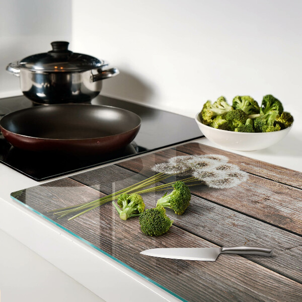 Tagliere in vetro temperato con motivo di fiori e soffioni su sfondo legno