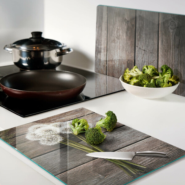 Tagliere in vetro temperato con motivo di fiori e soffioni su sfondo legno