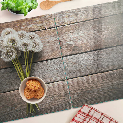 Tagliere in vetro temperato con motivo di fiori e soffioni su sfondo legno