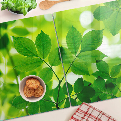 Tagliere in vetro temperato con motivo di foglie su sfondo verde
