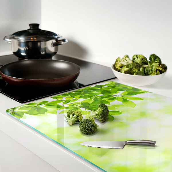 Tagliere in vetro con decorazione di foglie verdi alla luce