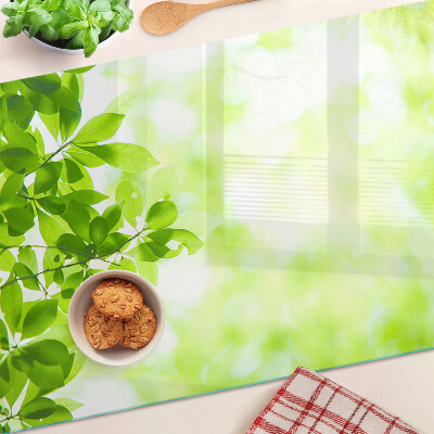 Tagliere in vetro con decorazione di foglie verdi alla luce