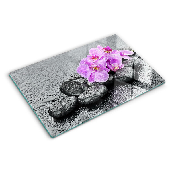 Tagliere in vetro temperato con motivo di fiori e pietre sullo sfondo dell'acqua