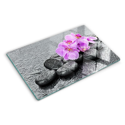 Tagliere in vetro temperato con motivo di fiori e pietre sullo sfondo dell'acqua