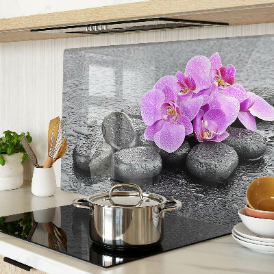 Tagliere in vetro temperato con motivo di fiori e pietre sullo sfondo dell'acqua