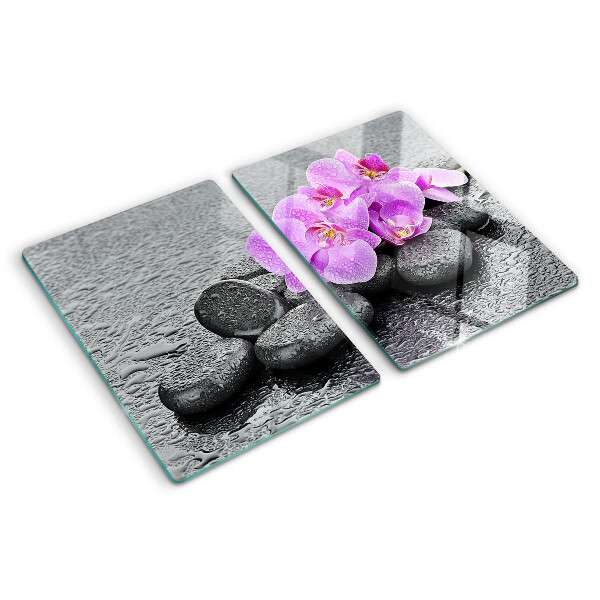 Tagliere in vetro temperato con motivo di fiori e pietre sullo sfondo dell'acqua