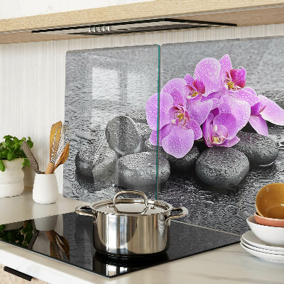 Tagliere in vetro temperato con motivo di fiori e pietre sullo sfondo dell'acqua