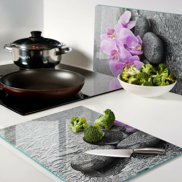 Tagliere in vetro temperato con motivo di fiori e pietre sullo sfondo dell'acqua