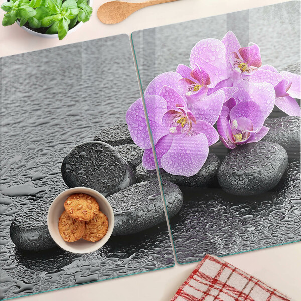 Tagliere in vetro temperato con motivo di fiori e pietre sullo sfondo dell'acqua