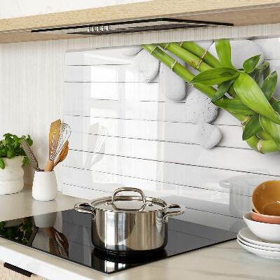 Tagliere in vetro temperato con motivo di bamboo e pietre su sfondo di legno