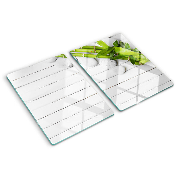 Tagliere in vetro temperato con motivo di bamboo e pietre su sfondo di legno