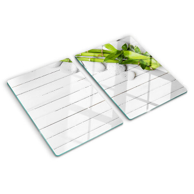 Tagliere in vetro temperato con motivo di bamboo e pietre su sfondo di legno