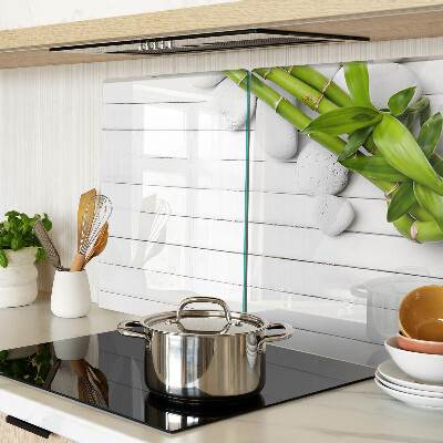 Tagliere in vetro temperato con motivo di bamboo e pietre su sfondo di legno