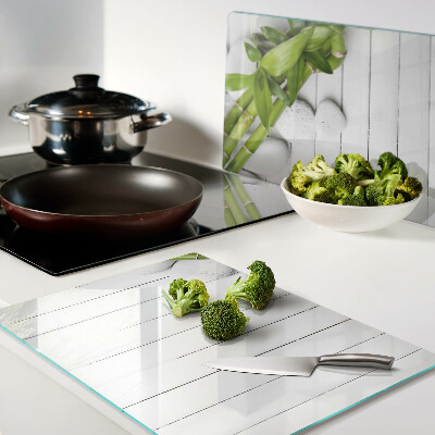 Tagliere in vetro temperato con motivo di bamboo e pietre su sfondo di legno