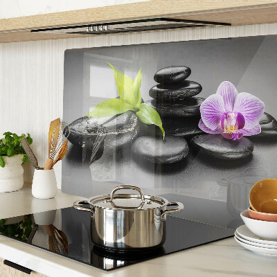 Tagliere in vetro con motivo di pietre e orchidea sullo sfondo