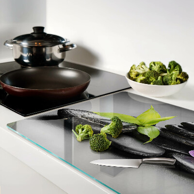 Tagliere in vetro con motivo di pietre e orchidea sullo sfondo