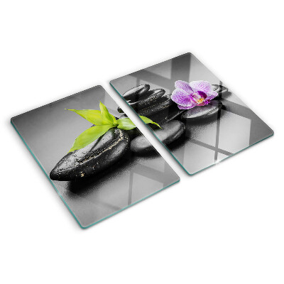 Tagliere in vetro con motivo di pietre e orchidea sullo sfondo