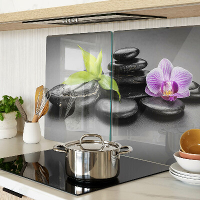 Tagliere in vetro con motivo di pietre e orchidea sullo sfondo