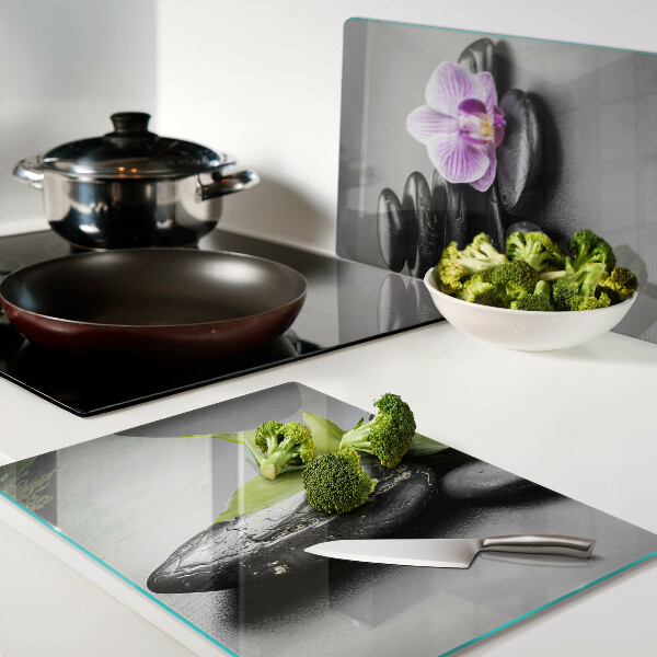 Tagliere in vetro con motivo di pietre e orchidea sullo sfondo