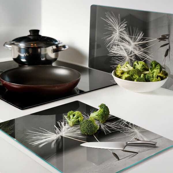 Tagliere in vetro con motivo di soffici denti di leone su sfondo monocromatico