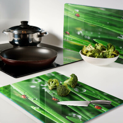 Tagliere in vetro con motivo gocce d'acqua sull'erba e coccinelle