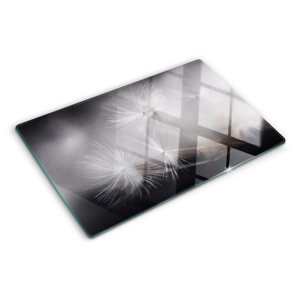 Tagliere in vetro con motivo di soffici denti di leone sullo sfondo della finestra