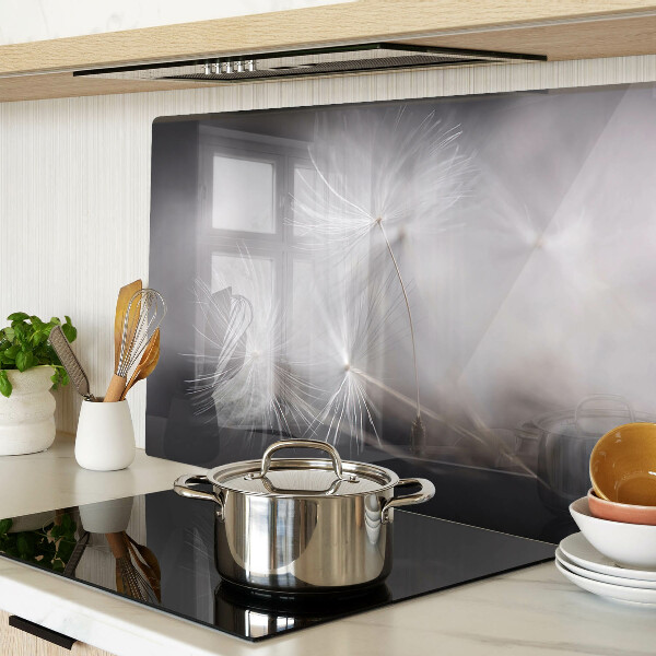 Tagliere in vetro con motivo di soffici denti di leone sullo sfondo della finestra