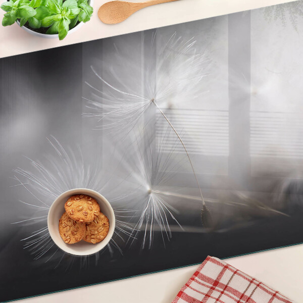 Tagliere in vetro con motivo di soffici denti di leone sullo sfondo della finestra