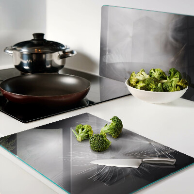 Tagliere in vetro con motivo di soffici denti di leone sullo sfondo della finestra