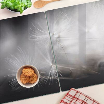 Tagliere in vetro con motivo di soffici denti di leone sullo sfondo della finestra