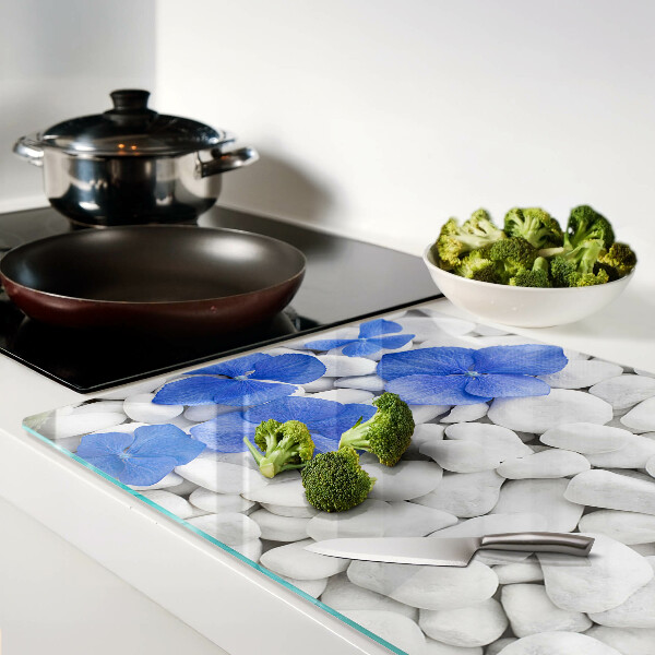 Tagliere in vetro temperato con motivo di fiori blu su sfondo di pietre bianche