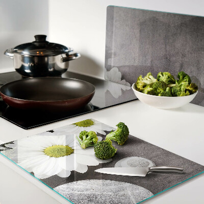 Tagliere in vetro temperato con decorazione a fiori e motivi pietrosi sullo sfondo