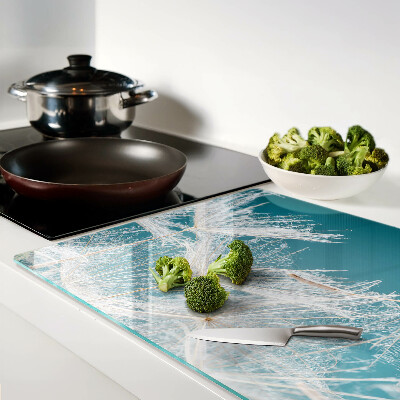 Tagliere in vetro temperato con motivo di denti di leone su sfondo blu