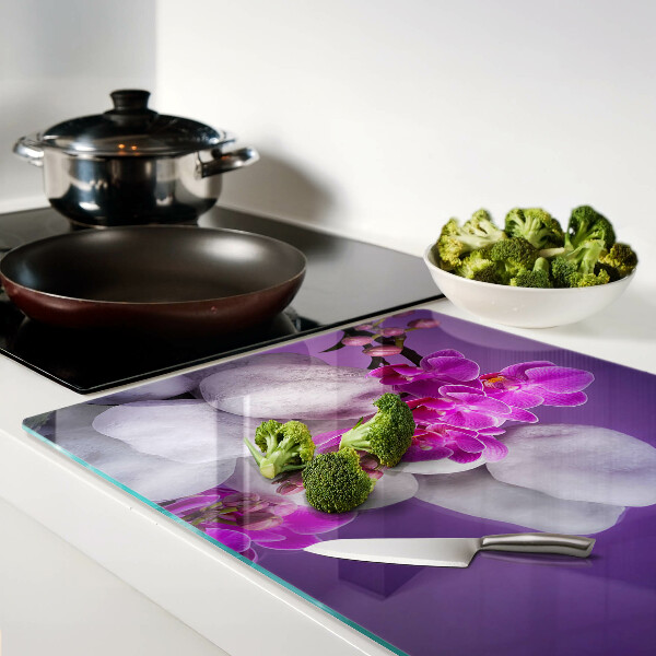 Tagliere in vetro temperato con motivo di fiori di orchidea su sfondo pietre