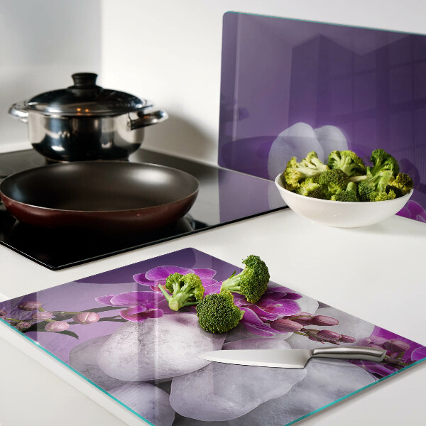 Tagliere in vetro temperato con motivo di fiori di orchidea su sfondo pietre