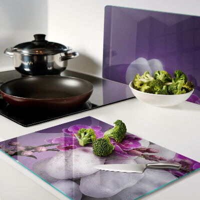 Tagliere in vetro temperato con motivo di fiori di orchidea su sfondo pietre