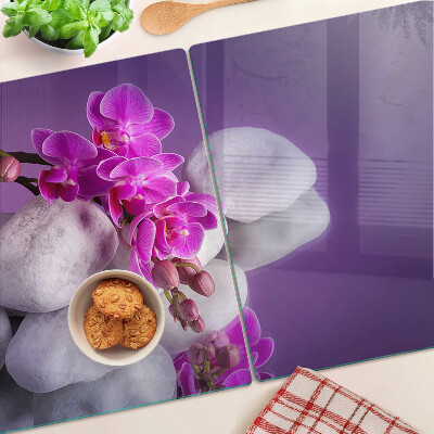 Tagliere in vetro temperato con motivo di fiori di orchidea su sfondo pietre