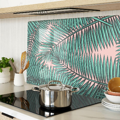 Tagliere in vetro con decorazione di foglie di palma su sfondo rosa