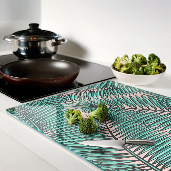 Tagliere in vetro con decorazione di foglie di palma su sfondo rosa