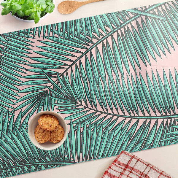 Tagliere in vetro con decorazione di foglie di palma su sfondo rosa