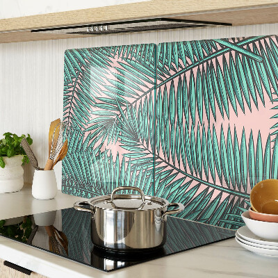 Tagliere in vetro con decorazione di foglie di palma su sfondo rosa