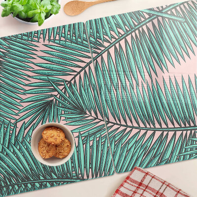 Tagliere in vetro con decorazione di foglie di palma su sfondo rosa