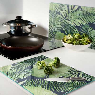 Tagliere in vetro temperato con motivo di foglie tropicali su sfondo scuro