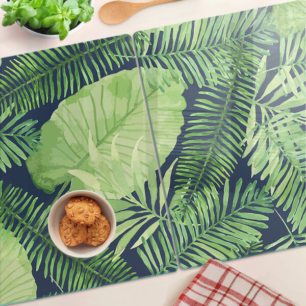 Tagliere in vetro temperato con motivo di foglie tropicali su sfondo scuro