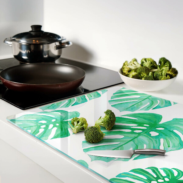 Tagliere in vetro con motivo di foglie di monstera su sfondo bianco