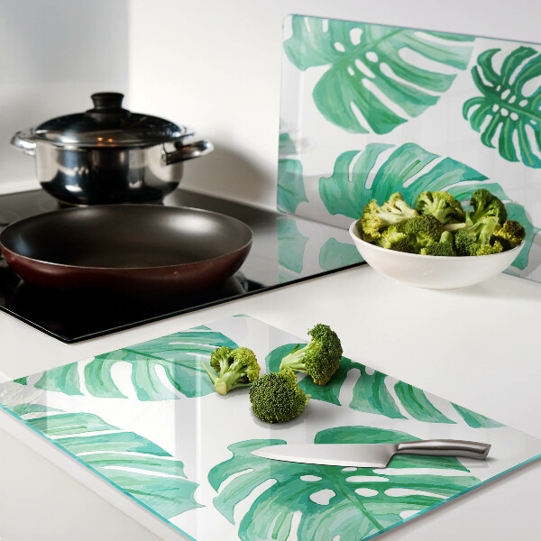 Tagliere in vetro con motivo di foglie di monstera su sfondo bianco