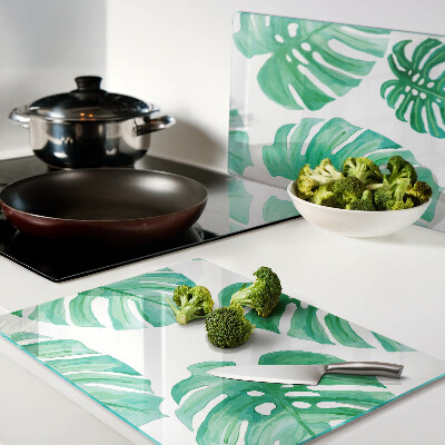 Tagliere in vetro con motivo di foglie di monstera su sfondo bianco